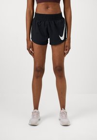 Shorts de sport noirs avec le logo swoosh blanc de Nike. Comprennent une taille élastique, un tissu léger et une coupe classique.