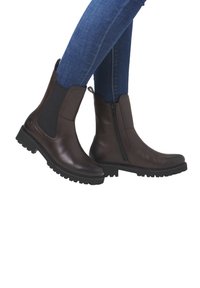 Brown leather Chelsea boots with side elastic panels and a zip, featuring a textured black rubber sole and a sleek, rounded toe design.