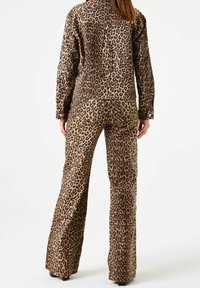 Jaguarprickig jacka och byxor-set, tillverkat av texturerad tyg, med bruna och beige toner, med framfickor och knappdetaljer.