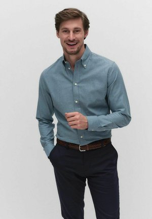 Light blue button-up shirt with a collar, long sleeves, and a textured fabric, paired with dark trousers and a braided brown belt.