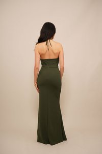 Rochie lungă, ajustată, dintr-un material elastic de culoare verde măsliniu. Design cu gât halter, cu un fermoar la spate și o fustă netedă, cu slit lateral.