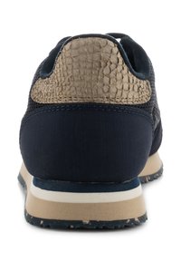Navy athletic shoe with a textured beige heel. Made from mesh and synthetic materials, featuring a chunky sole with horizontal stripes.