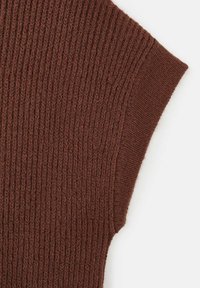 Top de punto acanalado marrón con un acabado texturizado, que presenta mangas cortas y un diseño de cuello barco ligero. El material parece suave y acogedor.