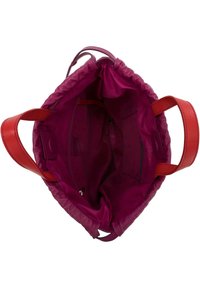 Sac fourre-tout en cuir violet avec des anses rouges, doté d'une fermeture à cordon. L'intérieur a une texture lisse, des poches latérales et un compartiment zippé.