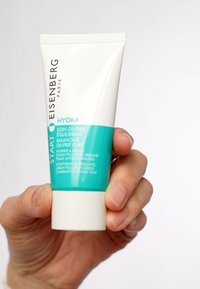 Witte tube met turquoise accenten, gelabeld "HYDRA" en "Soin Oil-Free." Tekst in het Frans en Engels die het gebruik voor de vette huid beschrijft.