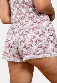 Un short court en tissu doux avec un fond rose orné d'un motif de feuilles en rouge et noir, accentué par une bordure en dentelle au niveau de l'ourlet.