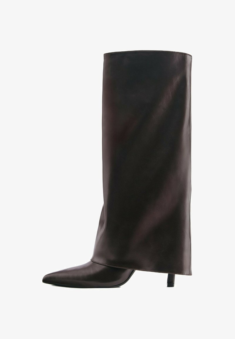 Botte haute noire en cuir avec un bout pointu et un talon fin de hauteur moyenne sur fond blanc.