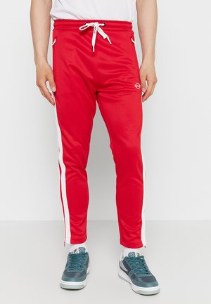 Rote Sporthosen mit tapered Fit, weißen Seitenstreifen, elastischem Bund, Kordelzugverschluss und Logodetail an der Oberschenkelseite.