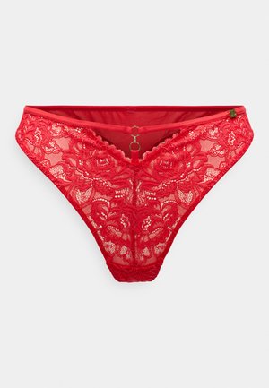 Červené čipkované tangá s kvetinovými vzormi, v tvare písmena V, s malým zlatým krúžkom na prednej strane a hladkým pásom.