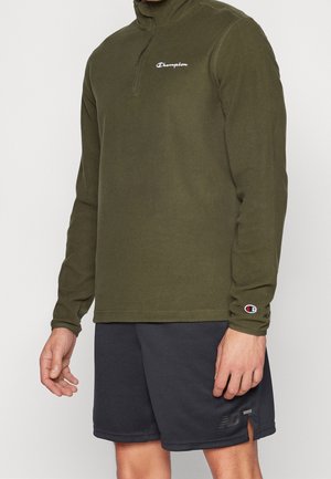 Pullover in pile verde oliva con mezza zip e colletto alto, dotato di ricamo bianco del logo sul petto e una piccola applicazione del logo sul manico.
