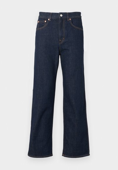 Jean denim bleu foncé à jambe droite avec bouton devant, braguette zippée et design à cinq poches.