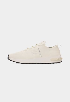 Off-white knitted low-top sneaker with lace-up front, black sole, and "Armani Exchange" text on side and heel tab.