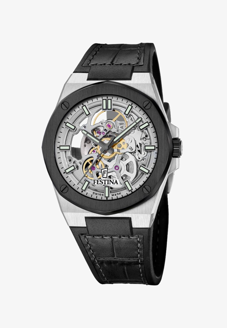 Montre-bracelet à cadran squelette avec engrenages visibles, lunette noire, boîtier en argent, index et aiguilles luminescents, et bracelet en cuir noir avec surpiqûres.