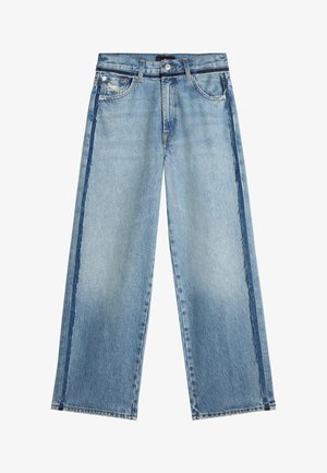 Jean large jambes bleu clair avec des bandes latérales plus foncées et un détail usé sur la partie supérieure de la poche gauche.