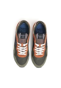 Idrottssneakers i mörkgrön med bruna mockadetaljer, försedd med vita snören, nätstruktur och en blå innersula märkt "LDN."