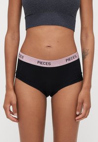 Černé bavlněné hipster kalhotky s třpytivým růžovým páskem s nápisem "PIECES". Design zahrnuje hladkou texturu a přiléhavý tvar.