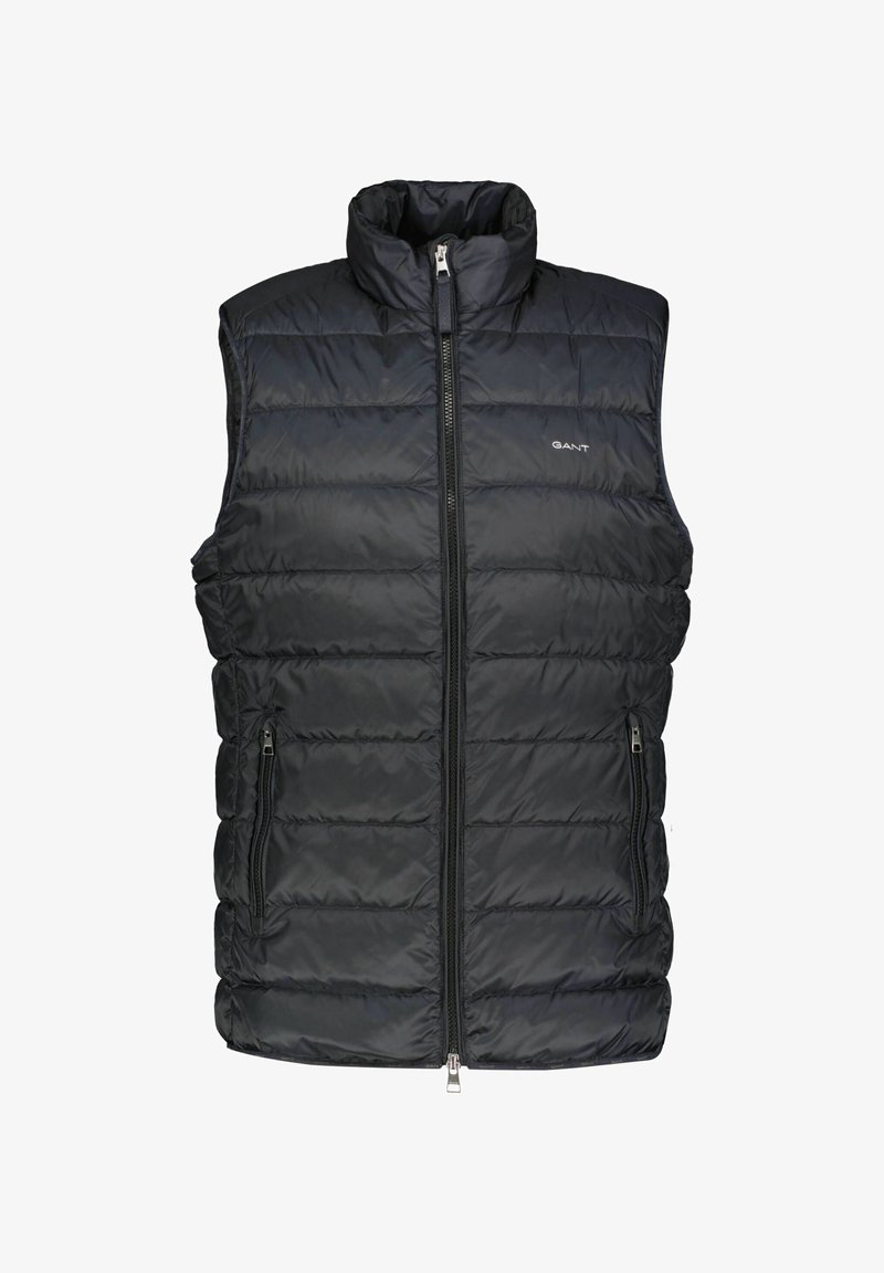 Veste sans manches matelassée noire avec fermeture éclair devant, deux poches zippées, col montant et petit logo GANT sur la poitrine.