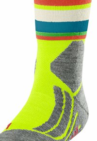Calzino sportivo giallo brillante con strisce multicolori, tallone e punta grigi, tessuto strutturato e accenti di design grafico neri.