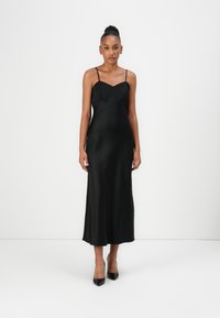 Black satin slip dress with a V-neckline and thin shoulder straps, featuring a straight cut and a smooth, glossy texture.