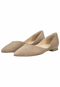 Mocasines de ante beige con punta afilada, tacón bajo y laterales abiertos, que presentan una textura suave y un diseño minimalista.