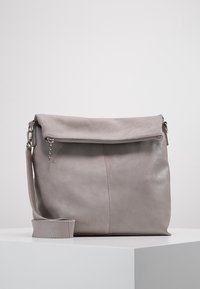 Šedá kožená taška přes rameno s překlápěcí klopou, zipovým uzávěrem a nastavitelným popruhem. Má hladký povrch a minimalistický design.