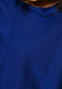 Tessuto lavorato a maglia blu con una texture liscia, caratterizzato da una scollatura girocollo e da un sottile dettaglio a linee diagonali sull'area del petto.