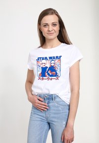 Camiseta de algodón blanca con un gráfico de "Star Wars" en azul y rojo que presenta personajes y texto en japonés. Corte slim con mangas cortas enrolladas.
