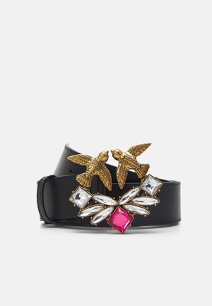 Schwarzer Ledergürtel mit goldener, vogelgestaltiger Schnalle, verziert mit klaren und rosa steinähnlichen Dekorationssteinen.