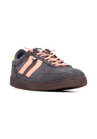 Zapatilla de gamuza gris con acentos rosas, presenta dos rayas laterales, cordones redondos y una suela de goma texturizada. Detalle amarillo en el talón.