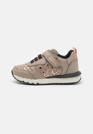 Sneaker beige con suola nera, caratterizzate da una fascia in velcro, lacci neri e dettagli splatter dorati metallici sulla parte superiore. Etichetta del marchio sul lato.