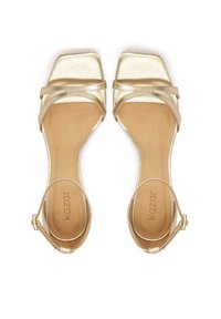 Gold metallic high-heeled sandals with a square toe, crisscross straps, and a thin ankle strap featuring a small buckle.