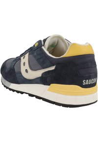 Dunkelmarineblauer und grauer Wildledersneaker mit gelben Akzenten, weißer Zwischensohle und schwarzer Gummisohle; verfügt über Logo und strukturierte Einsätze.