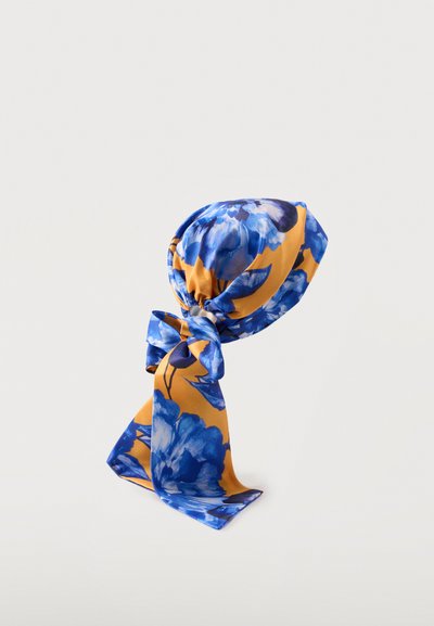 Μπλε και μουσταρδί κίτρινο φλοράλ φουλάρι δεμένο σε χαλαρό κόμπο σε απλό λευκό φόντο.