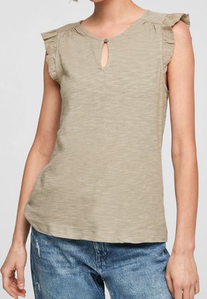 Beige mouwloos top met gerimpelde armsgaten en klein voorste keyhole knoopdetail, gedragen met blauwe jeans.