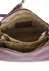 Interno di una borsa in pelle viola che mostra una fodera in tessuto beige con il logo "Pierre Cardin", una tasca con zip e diversi scomparti.