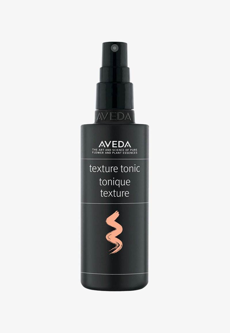 Aveda Texture Tonic spray i en sort cylindrisk flaske med en sort pumpe. Har hvid tekst og en koralfarvet swirl accent.