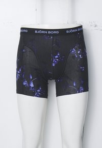 Crne bokserice s cvjetnim uzorkom u nijansama ljubičaste. Mekani materijal, elastična stražnja traka s logom "BJÖRN BORG", uski kroj.