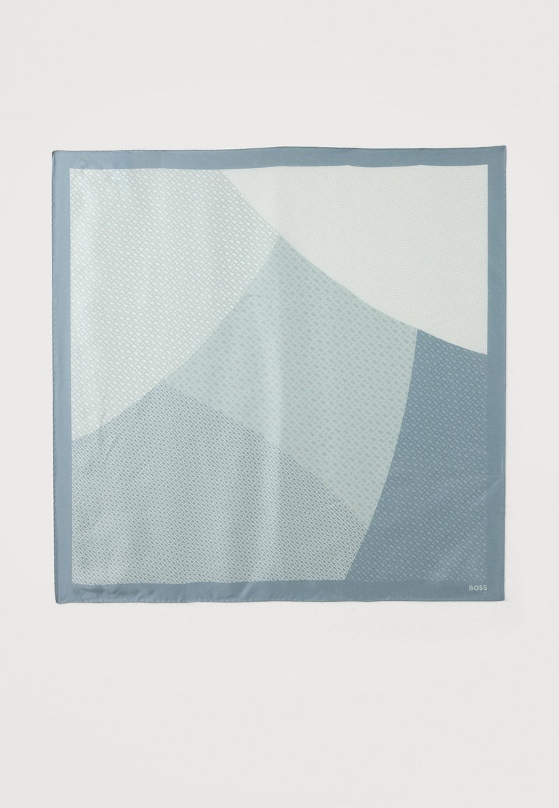 Τετράγωνο φουλάρι με γεωμετρικό μοτίβο σε αποχρώσεις του μπλε και του λευκού, με μικρές υφασμάτινες λεπτομέρειες και μονόχρωμη μπλε μπορντούρα.