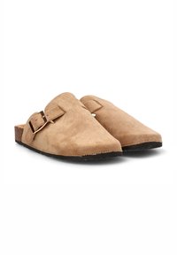 Mules de ante marrón con puntera redondeada, suela plana y un acento de hebilla lateral. Textura suave y diseño minimalista.