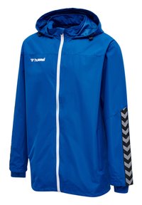 Giacca a vento blu con cappuccio, zip bianca e motivo a chevron nero sulle maniche. Realizzata in materiale leggero e resistente all'acqua.
