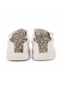 Baskets blanches avec un accent scintillant or et argent au talon, présentant une surface en cuir lisse et une semelle en caoutchouc texturée.