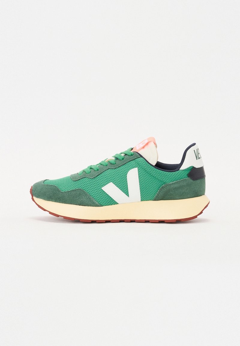Green mesh and suede sneaker with white V logo and pink accents. Features a textured upper, cushioned midsole, and rubber outsole.