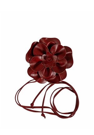 Flor de cuero rojo oscuro con múltiples pétalos en capas, unida a largas y delgadas correas de cuero.