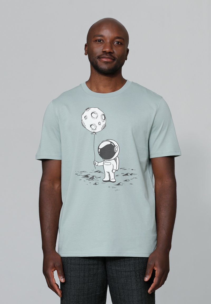 Lichtblauw katoenen t-shirt met korte mouwen en een ronde hals, met een cartoon-astronaut die een maanballon vasthoudt.