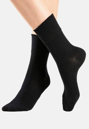 Schwarze Knöchelsocken aus einem glatten, dehnbaren Material mit einem eng anliegenden Bündchen und nahtlosem Zehendesign, geeignet für legere Outfits.