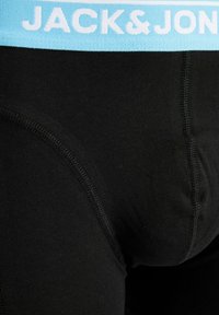 Sorte boxershorts med en lyseblå linning med "JACK&JON" i hvid tekst, lavet af blødt, elastisk stof med forstærkede syninger.