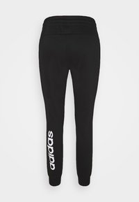 Schwarze Jogginghosen mit elastischem Bund, zulaufenden Beinen und weißem "adidas"-Logo, das vertikal am linken Bein aufgedruckt ist. Weiche Stoffstruktur.
