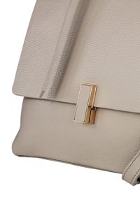 Sac à main en cuir gris clair avec une finition texturée, doté d'un fermoir en métal doré et d'une fermeture à rabat. Forme arrondie et accents cousus.
