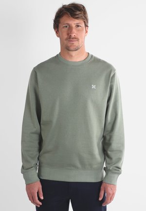 Sweatshirt en coton vert avec un col rond et des manches longues. Présente un petit logo blanc sur la poitrine et des poignets et un ourlet en côte.