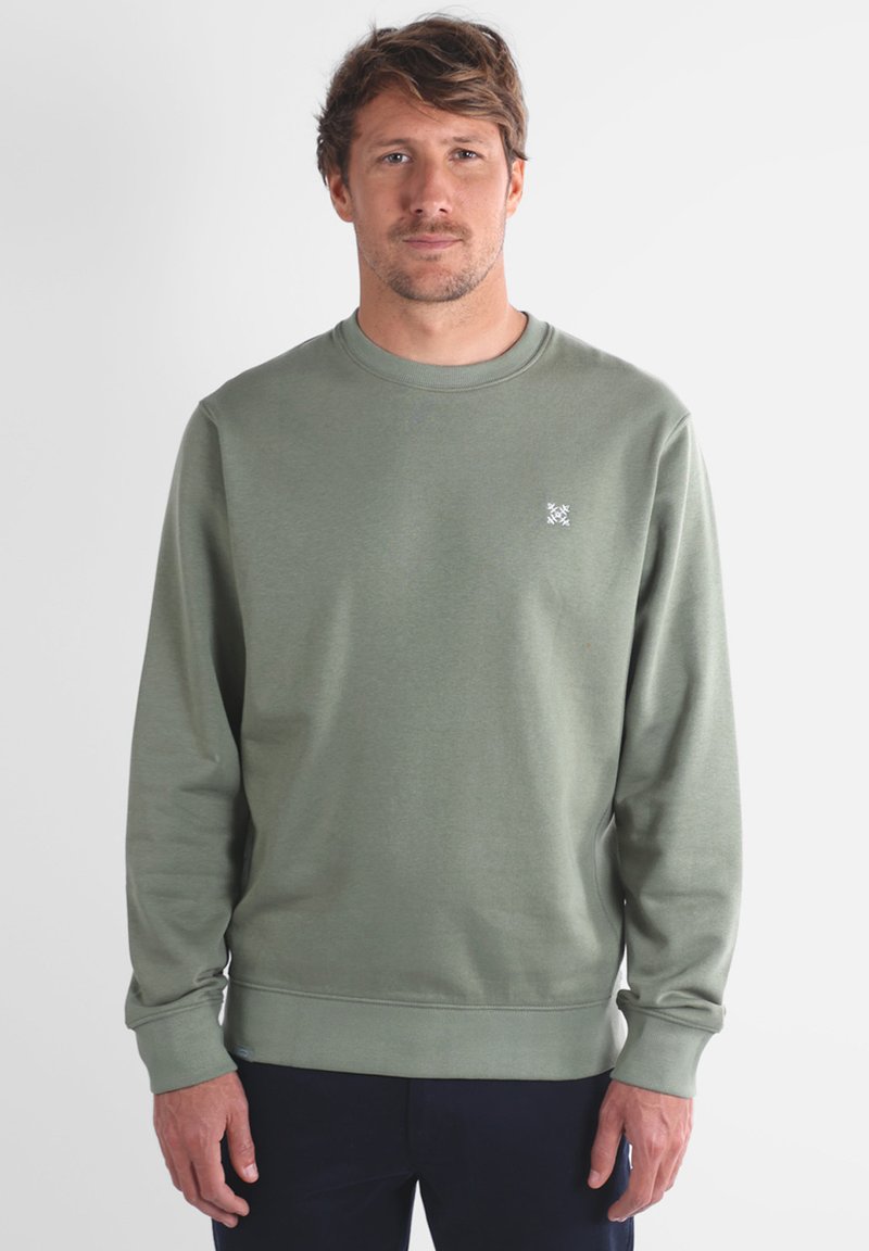 Sweatshirt en coton vert avec un col rond et des manches longues. Présente un petit logo blanc sur la poitrine et des poignets et un ourlet en côte.